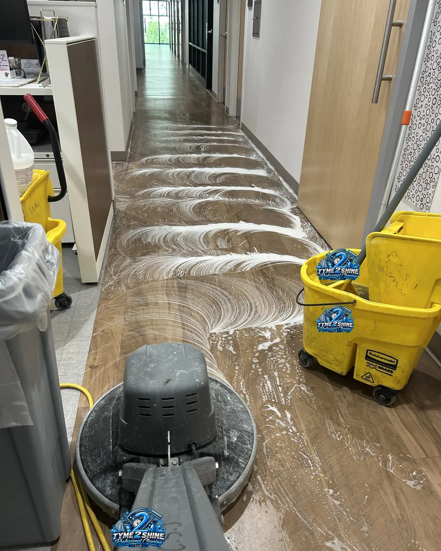 Tyme 2 Shine Professionals crew machine-scrubbing a hallway floor